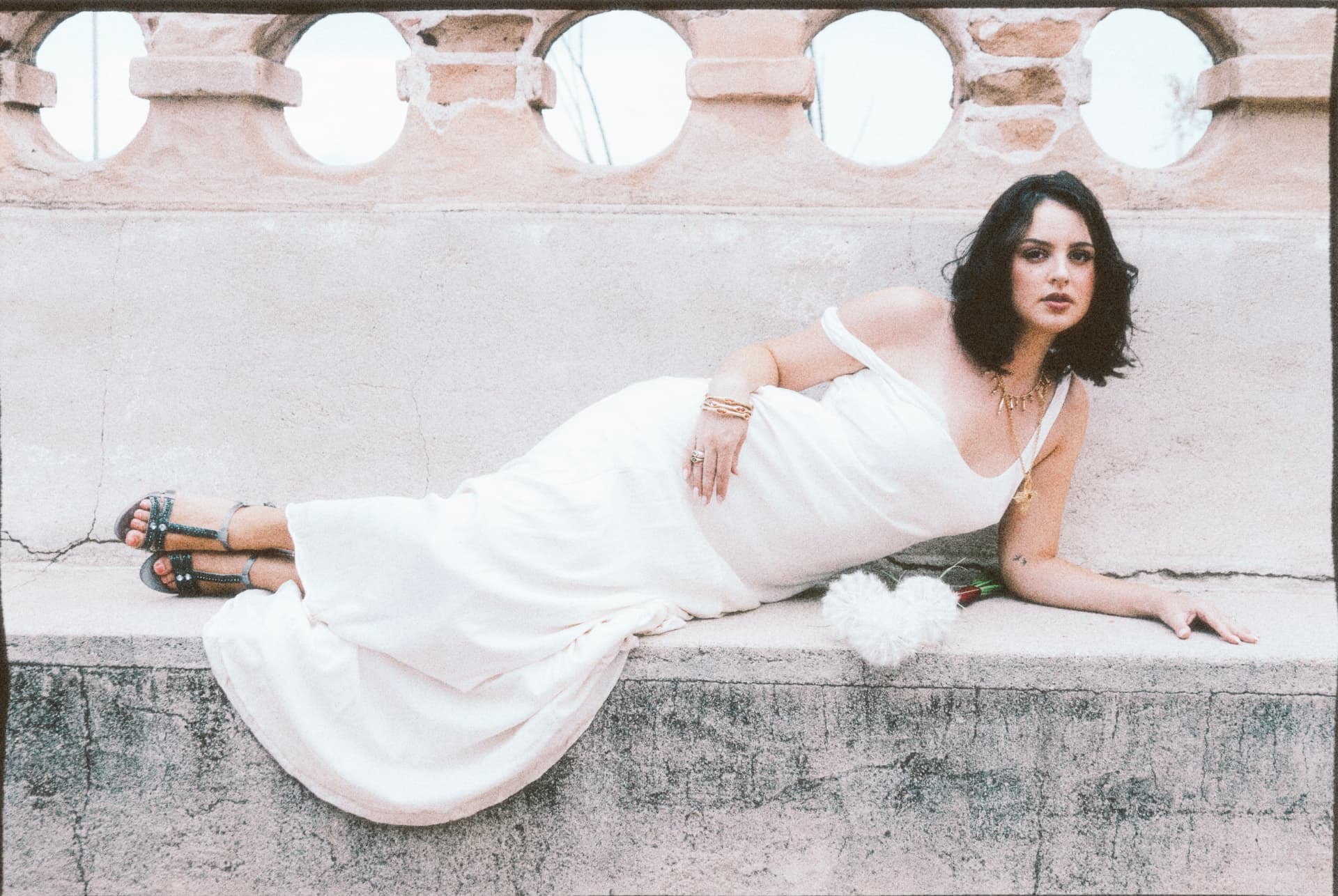 Bride reclining in an ivory gown on a stone bench